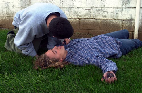 Person checking critical signs of person laying on the ground