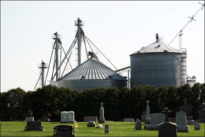 Photo of a cemetary in front of grain bins