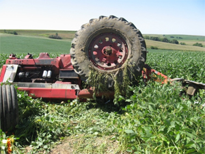 An upside-down tractor in a field