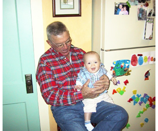 Photo of an older farmer holding a baby