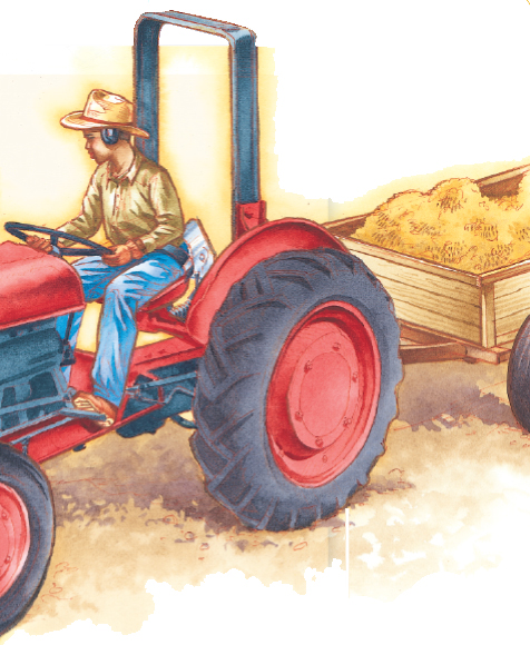 Young boy operating a tractor trailing a cart filled with soil