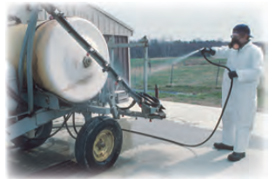 man wearing coveralls while applying pesticides