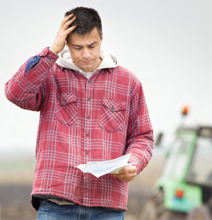 man holding and reading a paper in a field