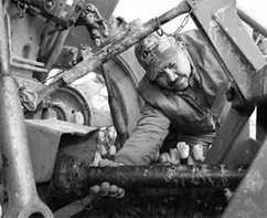man inspecting the PTO of a tractor